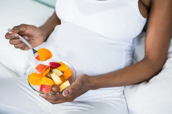 Mulher grávida comendo salada de frutas — Fotografia de Stock