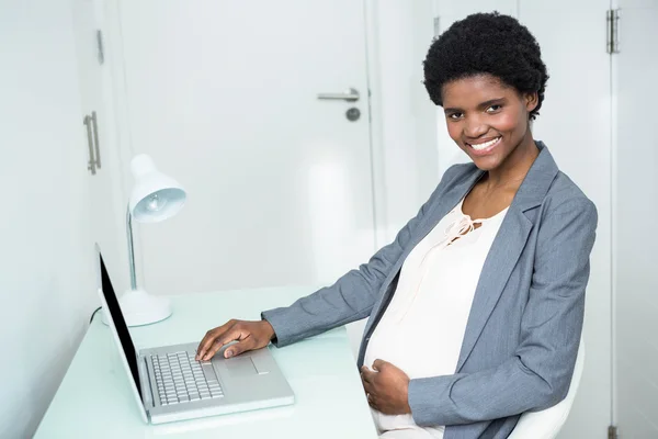 Těhotná moderátorka pracuje na notebooku — Stock fotografie