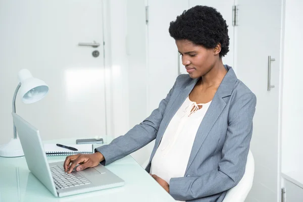 Schwangere Geschäftsfrau benutzt Laptop — Stockfoto