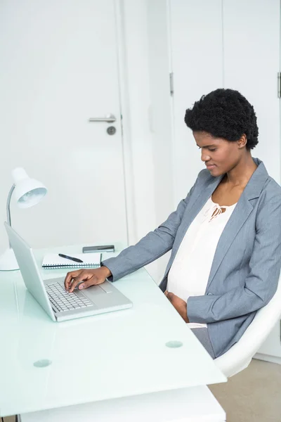 Schwangere Geschäftsfrau benutzt Laptop — Stockfoto