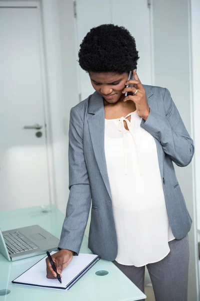 Zwangere zakenvrouw schrijven op laptop — Stockfoto