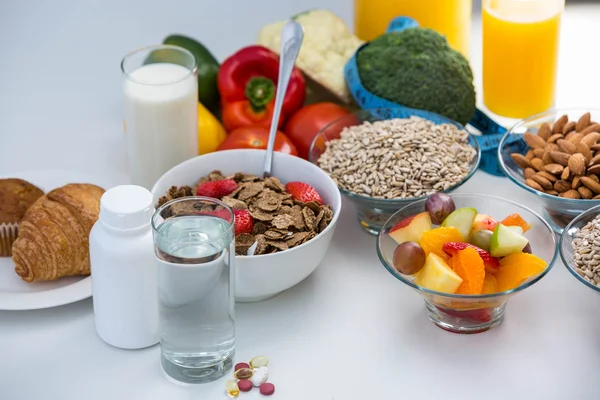 Vista del tazón de cereales, pastillas y alimentos — Foto de Stock