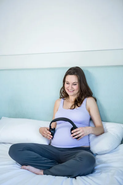 Embarazada haciendo su golpe escuchar música con auriculares —  Fotos de Stock