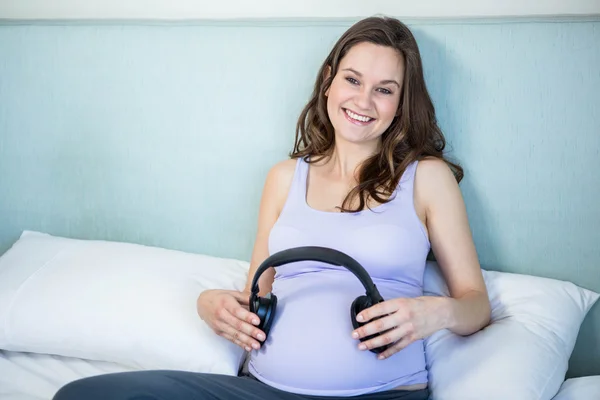 Zwanger maken van haar hobbel luisteren naar muziek met koptelefoon — Stockfoto