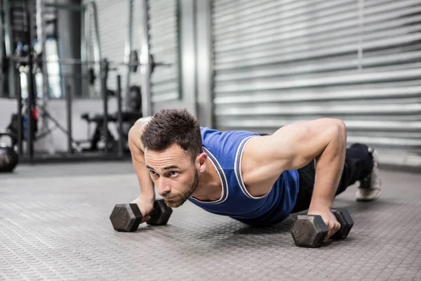 Muscular man doing push up with dumbbells — Stock Photo, Image