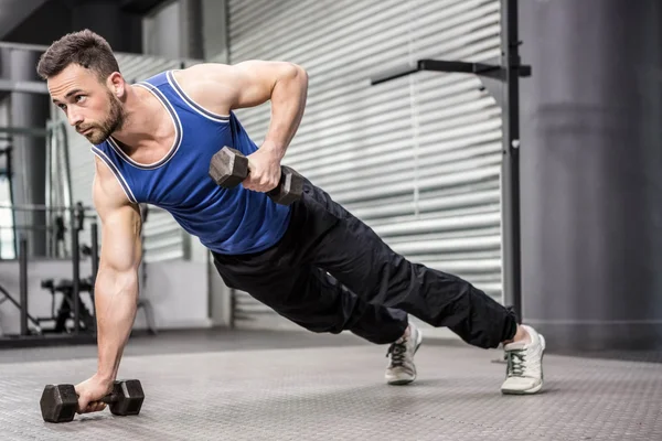 Muscular man doing push up with dumbbells — Stock Photo, Image