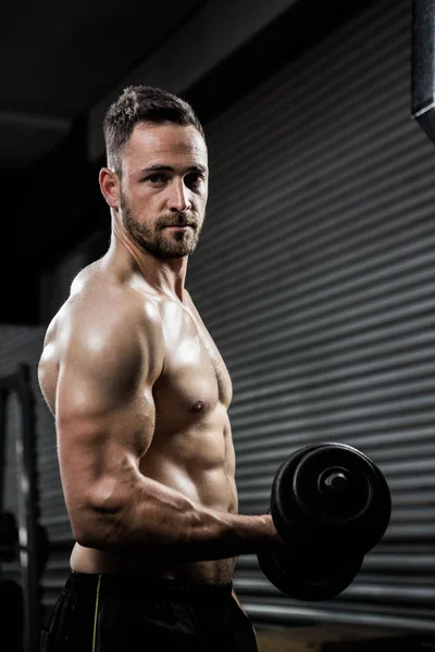 Shirtless man lifting heavy dumbbell — Stock Photo, Image