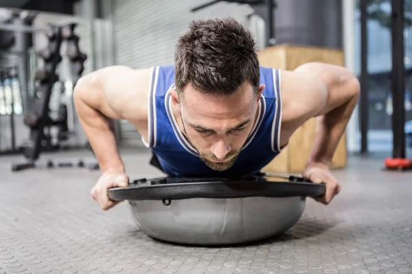 Muscular man doing push up on bosu ball — Stock Photo, Image