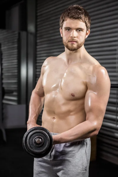 Homem sem camisa levantando halteres pesados — Fotografia de Stock