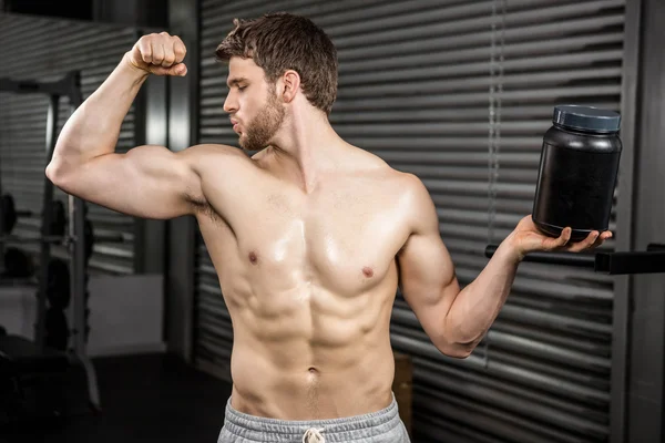 Shirtless man showing biceps and holding can — Stock Photo, Image