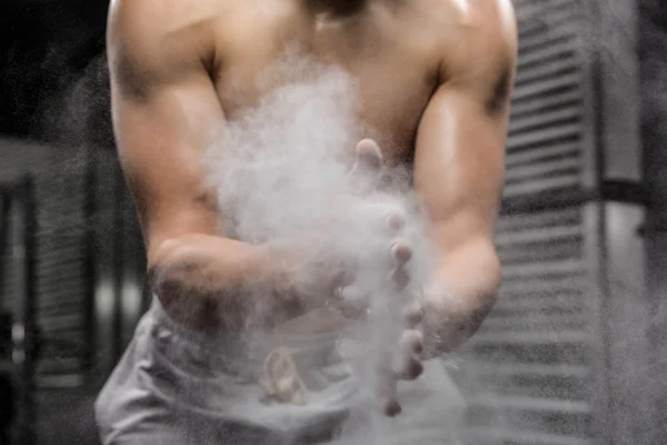 Seção média de homem sem camisa batendo palmas com talco — Fotografia de Stock
