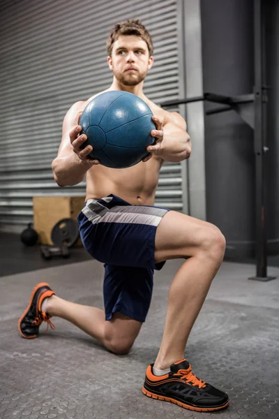 Hombre sin camisa entrenando con balón de medicina — Foto de Stock