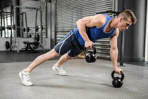 Muskulöser Mann macht Liegestütze mit Kettlebells — Stockfoto