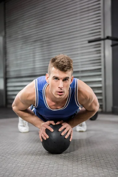 Muscular man doing pull up with medicine ball — Stock Photo, Image