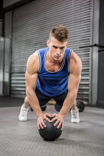 Hombre musculoso haciendo tire hacia arriba con la bola de la medicina — Foto de Stock