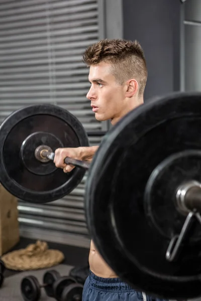 Shirtless man hijs barbell — Stockfoto