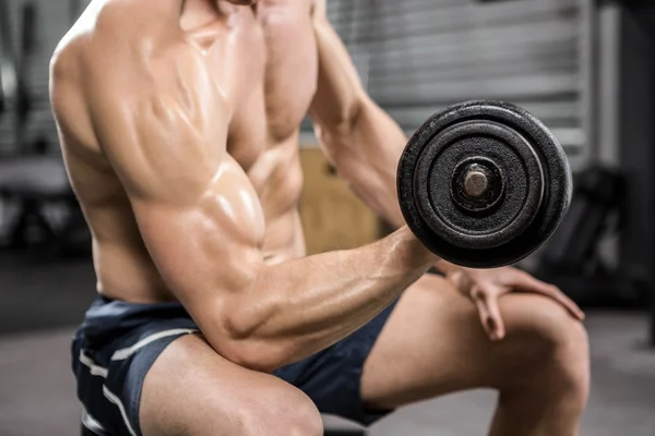 Hombre sin camisa levantando pesadas mancuernas en el banco — Foto de Stock