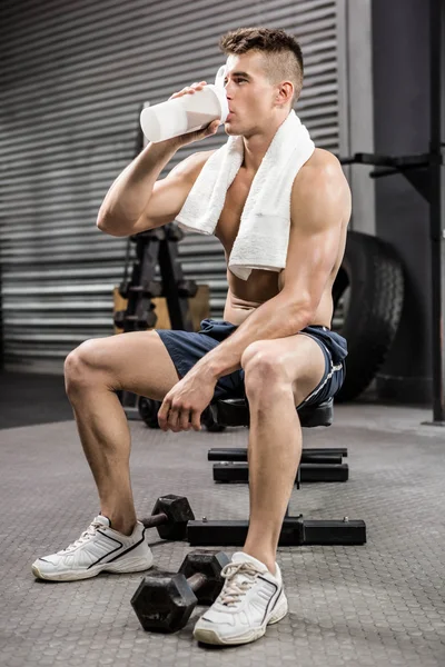 Hombre sin camisa en banco bebiendo batido de proteína —  Fotos de Stock