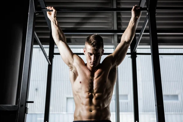 Hombre sin camisa haciendo tire hacia arriba — Foto de Stock