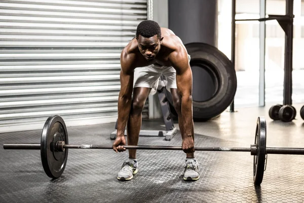 Homem sem camisa levantando barbell — Fotografia de Stock