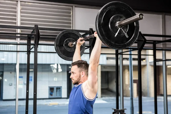 Homem muscular levantando barbell — Fotografia de Stock