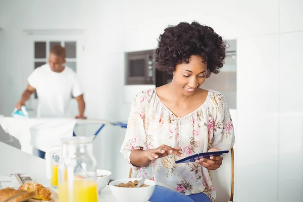 Morena usando tablet na cozinha — Fotografia de Stock