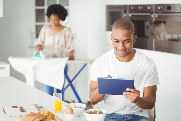 A fiatalember tabletta használata a konyhában — Stock Fotó