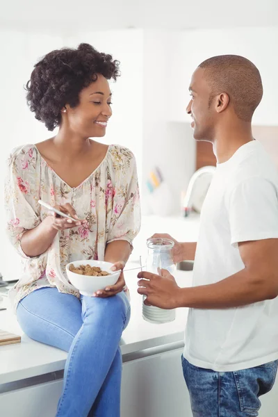 Happy couple eating breakfast and using smartphone — Stok fotoğraf