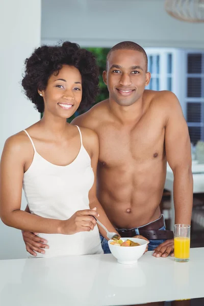 Happy couple eating breakfast in the kitchen — Stock Photo, Image