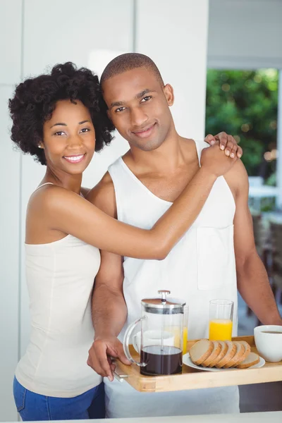 Pareja feliz sosteniendo bandeja de desayuno en la cocina —  Fotos de Stock