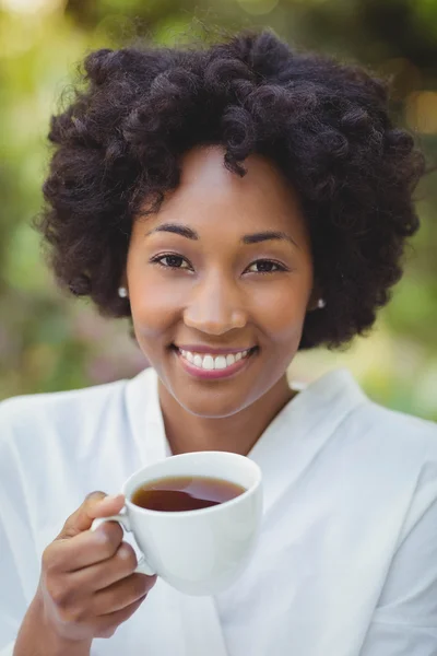 Smiling woman holding tea — Zdjęcie stockowe