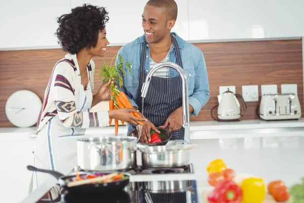 Happy couple washing vegetables — 图库照片