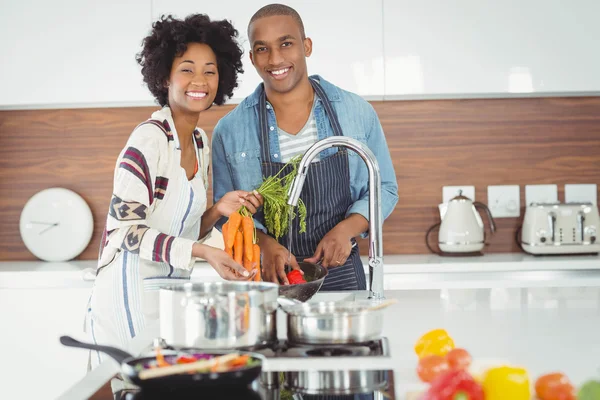 Happy couple washing vegetables — Stok fotoğraf