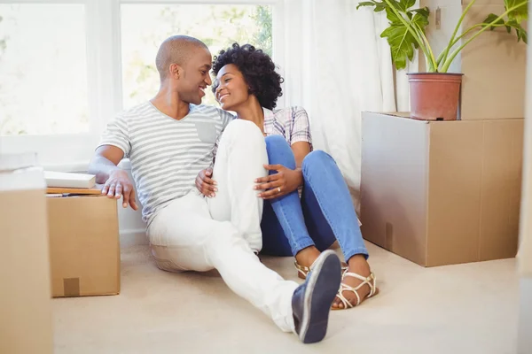 Happy couple sitting on the floor — Stock Photo, Image