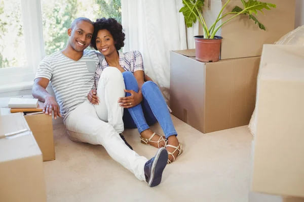 Happy couple sitting on the floor — Stock Photo, Image