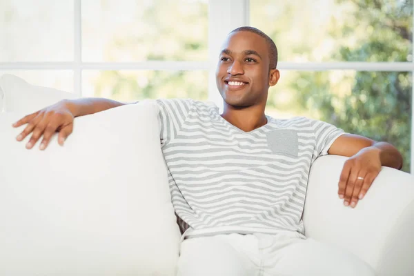 Przystojny mężczyzna siedzi na kanapie — Zdjęcie stockowe