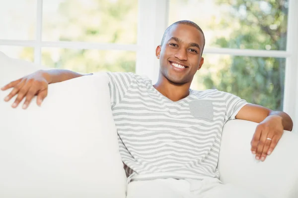 Красивый мужчина, сидящий на диване — стоковое фото