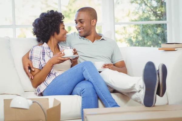 Glückliches Paar auf dem Sofa beim Kaffeetrinken — Stockfoto