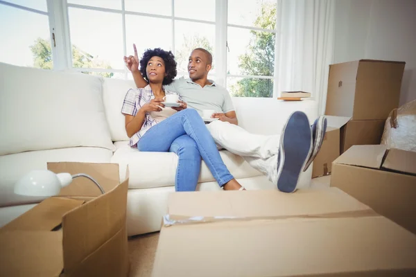 Happy couple on the sofa having coffee — Stockfoto