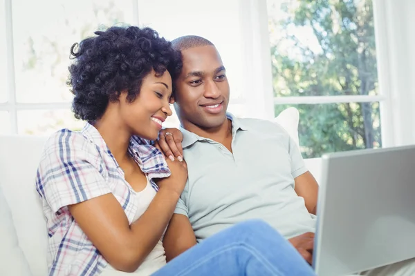 Couple heureux en utilisant un ordinateur portable sur le canapé — Photo