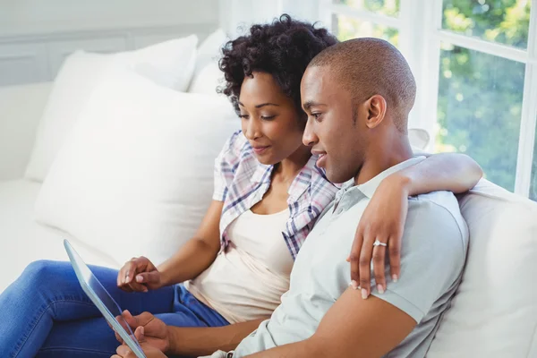 Couple heureux en utilisant une tablette sur le canapé — Photo