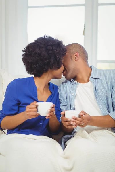 Счастливая пара целуется на диване — стоковое фото