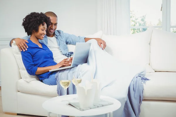 Happy couple on the sofa using laptop — Stock Fotó