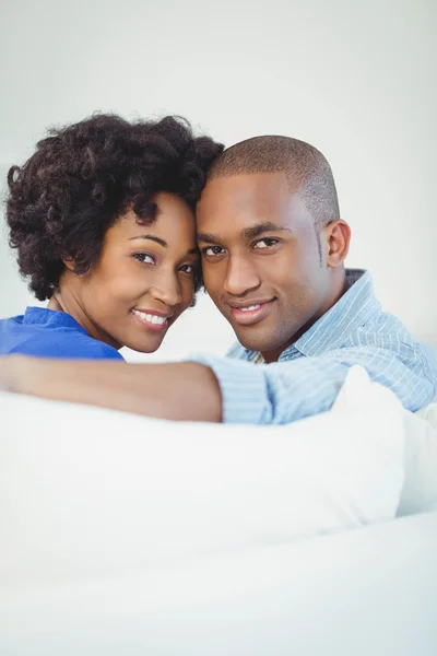 Portrait of smiling couple on the sofa — Stock fotografie