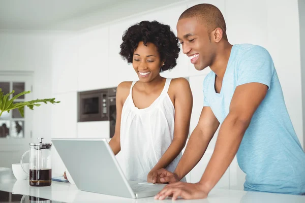 Lyckliga paret med laptop i köket — Stockfoto