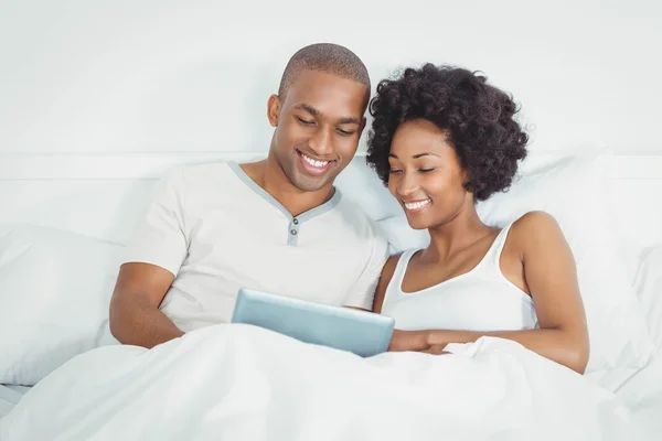 Glückliches Paar mit Tablet im Bett — Stockfoto