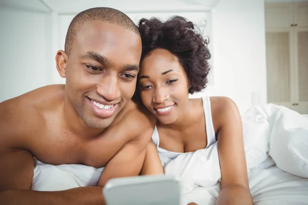 Pareja sonriente usando smartphone — Foto de Stock