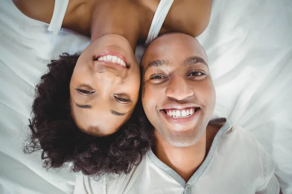 Pareja feliz acostada en la cama — Foto de Stock