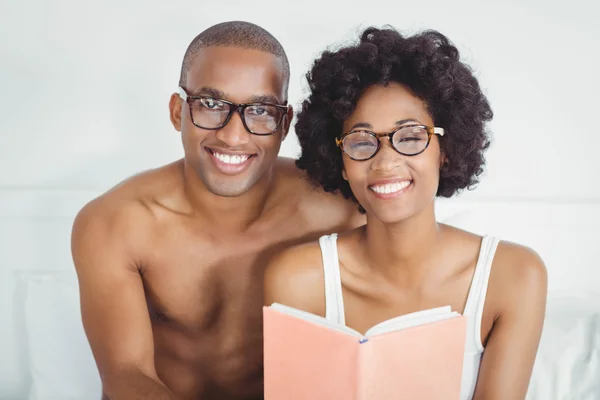 Happy couple reading a book together — Stockfoto