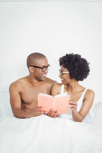 Happy couple reading a book together — Stockfoto